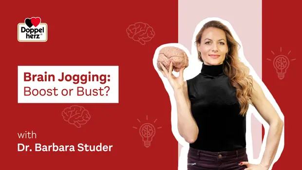 Imagen de una mujer sosteniendo un modelo de cerebro, vestida con una blusa negra. El texto destaca "Brain Jogging: Boost or Bust?" y menciona a la Dra. Barbara Studer. El fondo es de color rojo con elementos gráficos relacionados con ideas y creatividad.